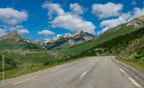 Empty asphalt road runs through the idyllic countryside in the French Alps.