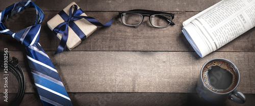  Tie, Belt, And Gift Box With Reading Glasses, Newspapers, And Coffee On Wooden Table - Fathers Day Concept