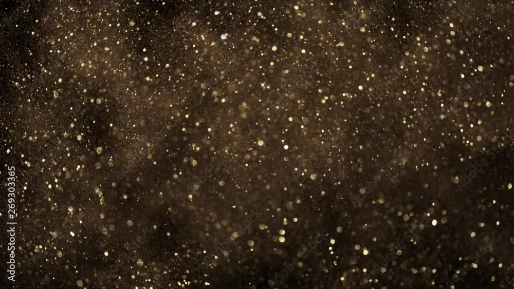 Super slow motion of glittering golden particles on black background. Shallow depth of focus. Filmed on high speed cinema camera, 1000 fps. Super slow motion of glittering golden particles on black background. Shallow depth of focus. Filmed on high speed cinema camera, 1000 fps.