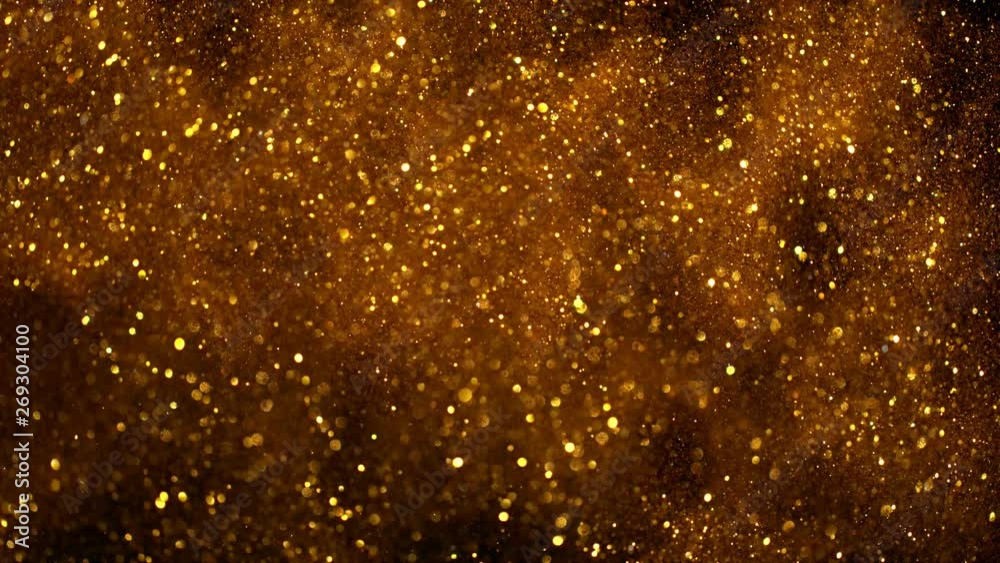 Super slow motion of glittering golden particles on black background. Shallow depth of focus. Filmed on high speed cinema camera, 1000 fps. Super slow motion of glittering golden particles on black background. Shallow depth of focus. Filmed on high speed cinema camera, 1000 fps.