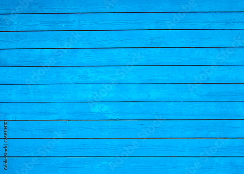 Background, texture - the blue wall of the village house from painted wooden boards