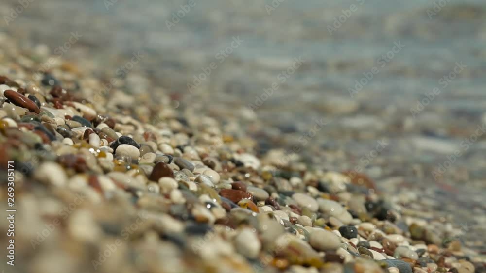 waves roll on the seashore with pebbles. beautiful blurred highlights and bokeh on the beach with sea waves, pebbles and sunbeam waves roll on the seashore with pebbles. beautiful blurred highlights and bokeh on the beach with sea waves, pebbles and sunbeam