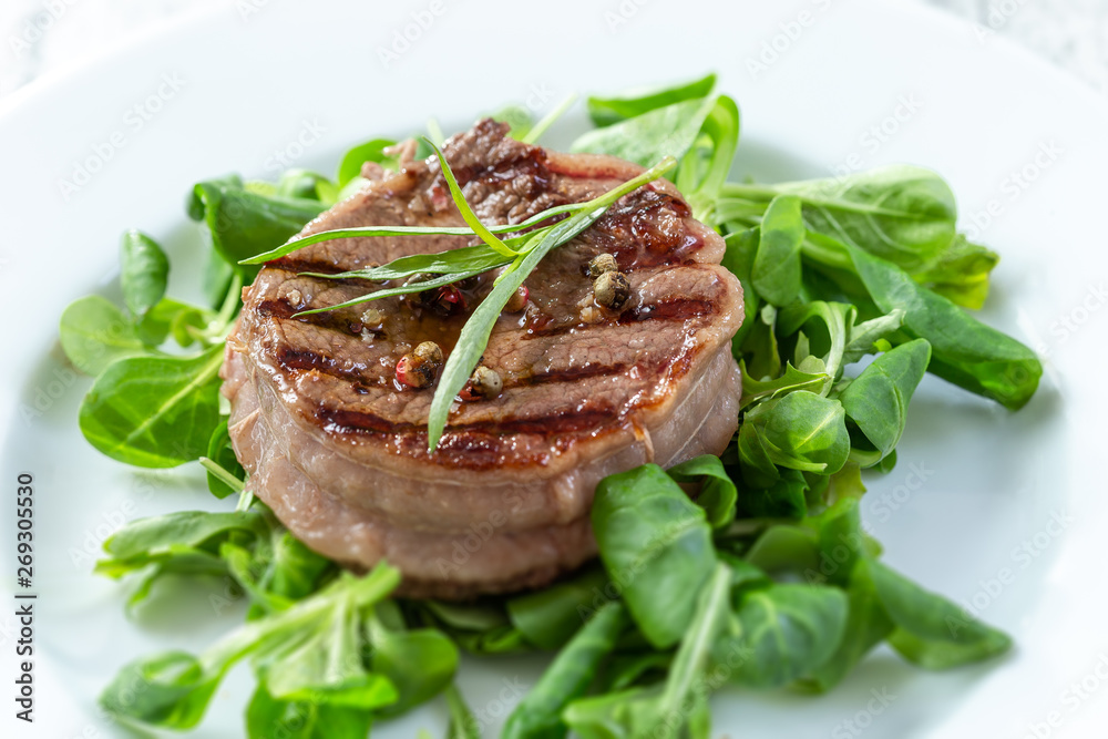 Rump Steak with Green vegetable, spinach,, pepper close up on plate Rump Steak with Green vegetable, spinach,, pepper close up on plate