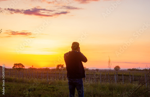 man takes a sunset photo