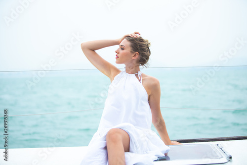 beautiful woman in white dress enjoying luxurious yacht cruise