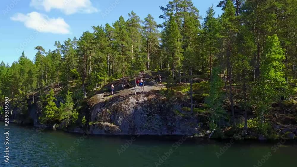 Three guys jumping from a cliff to water Three guys jumping from a cliff to water
