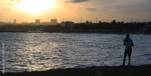 silhouette of a fisherman at sunset