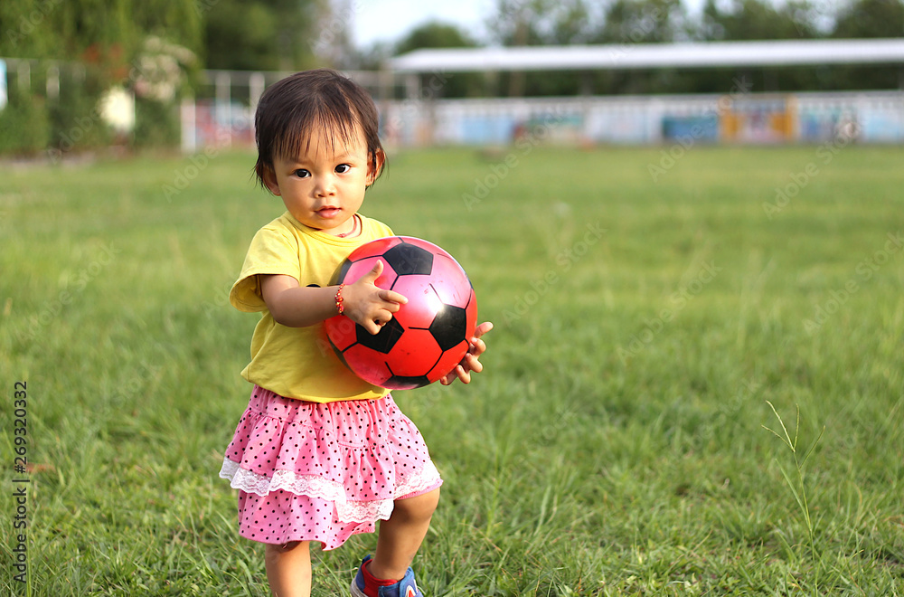 Happy Asian baby child girl playing ball toys at the field playground. She smiling and wearing a yellow shirt. Baby aged of one year old. Happy Asian baby child girl playing ball toys at the field playground. She smiling and wearing a yellow shirt. Baby aged of one year old.