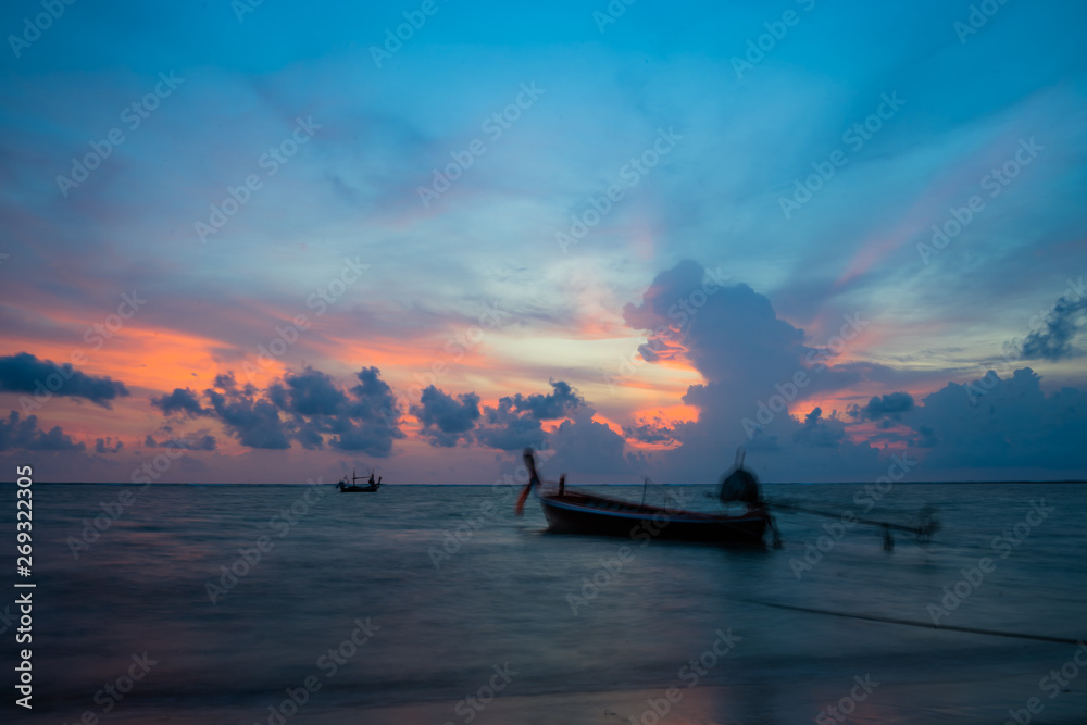 Sunset with thai boat evening at Nai Yang Beach Phuket Thailand.