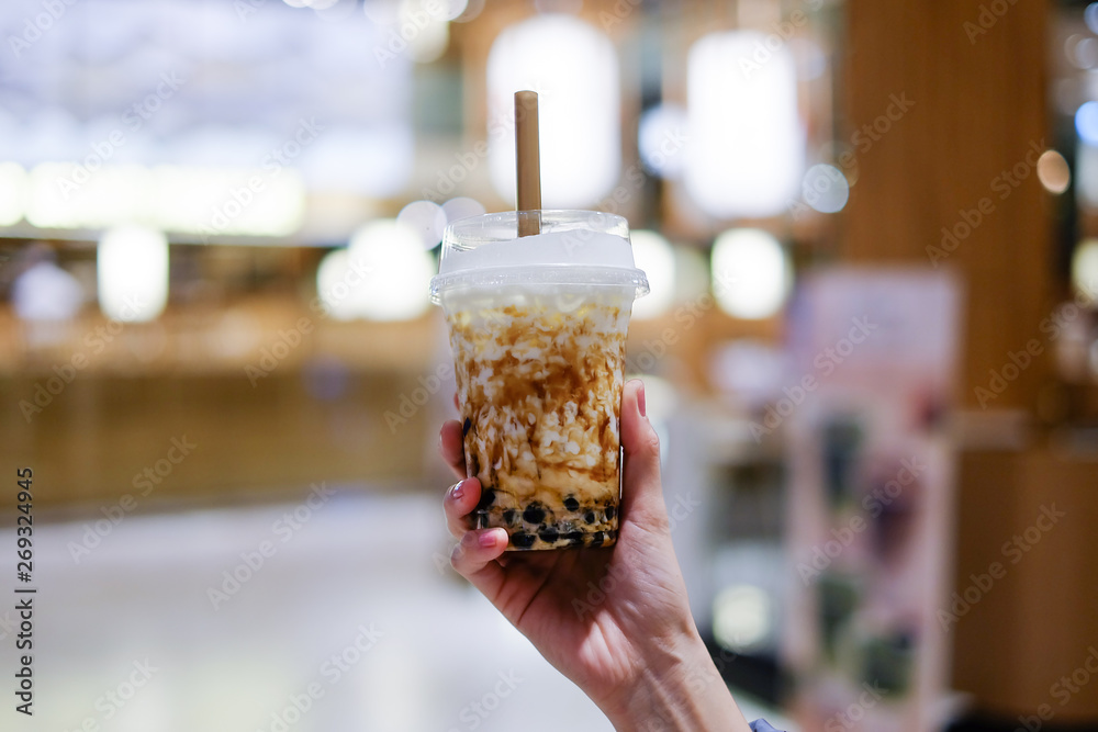 brown sugar bubble milk tea in plastic cup, hand holding a cup of fresh ...