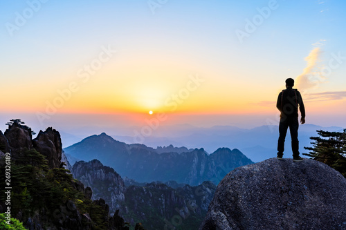 Young happy backpacker on top of a mountain enjoying valley view © ABCDstock