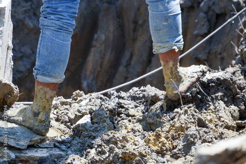 Obraz premium Worker barefoot and walking on mud in sunny day.