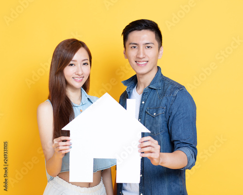 young couple showing  house sign for new home concepts photo