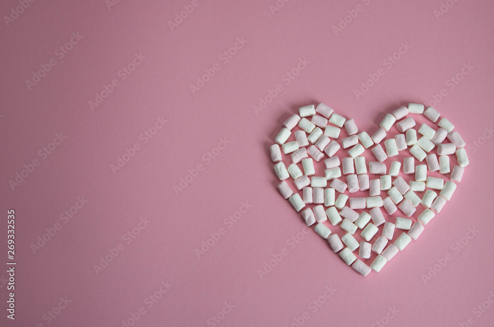 heart laid out of white and pink mini marshmallows on a pink background heart laid out of white and pink mini marshmallows on a pink background
