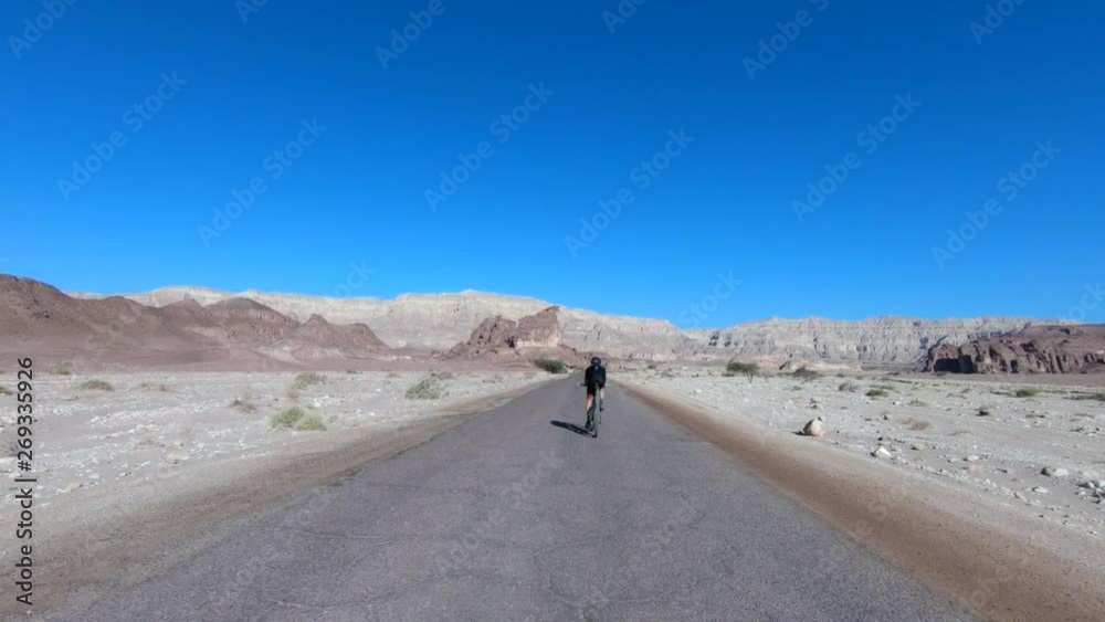 Cyclist riding on an empty Single Desert road, Follow footage. Cyclist riding on an empty Single Desert road, Follow footage.