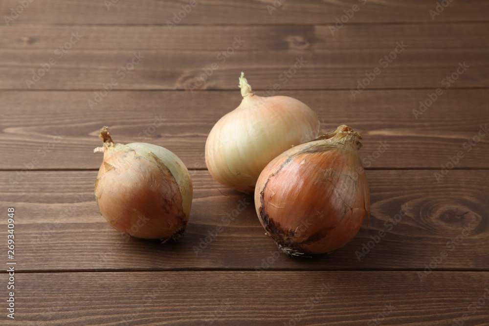 Fototapeta premium 木のテーブルにのせた生のタマネギ