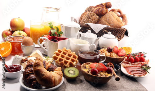 Huge healthy breakfast on table with coffee, orange juice, fruits, waffles and croissants. Good morning concept.