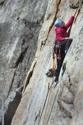 Young woman is engaged in rock climbing in the mountains. Sport climbing. © esalienko