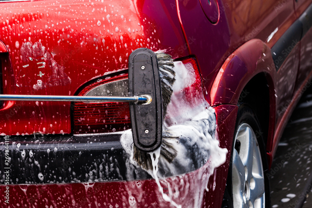 Naklejka premium manual car washing with pressurized water and soap in car wash outdoor