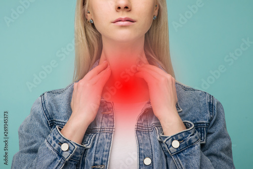 A young girl has a sore throat. Thyroid problems photo