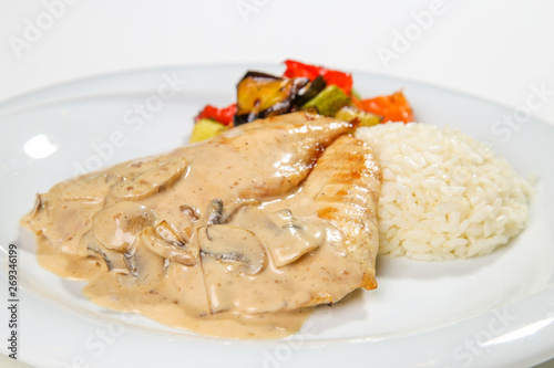 mushroom and cream sauced marinated grilled chicken isolated white background with side dishes