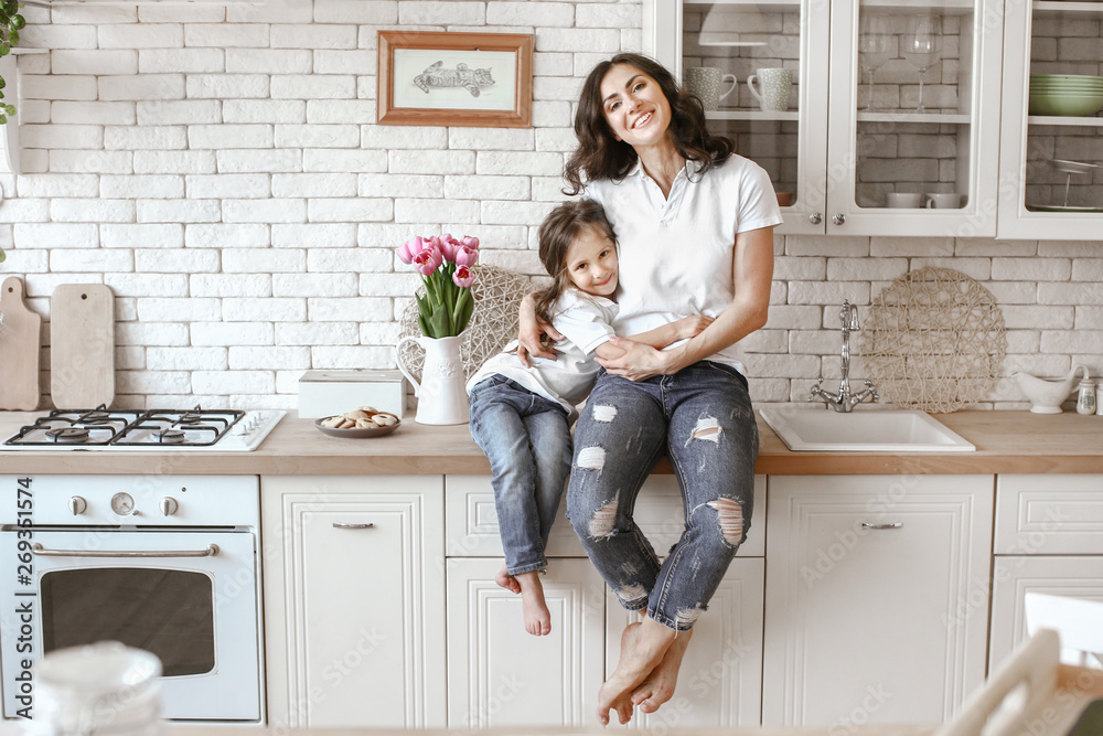 Happy mother with daughter in kitchen at home - obrazy, fototapety, plakaty 