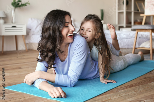Mother with little daughter doing exercises at home