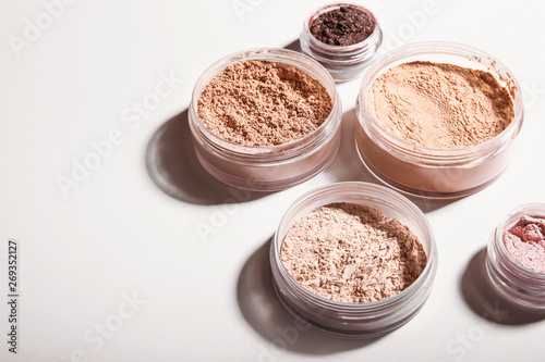 Different facial powder on light background