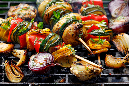 Vegetarian skewers, grilled vegetable skewers of zucchini, peppers and potatoes with the addition of aromatic herbs and olive oil on the grill outdoors. Grilled food