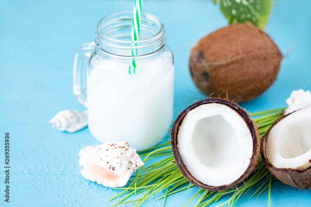 Coconut fruit whole and half, coconut milk on blue background Coconut fruit whole and half, coconut milk on blue background