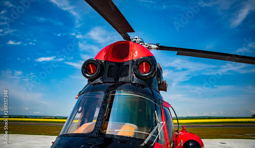red and black helicopter standing at the airfield close up