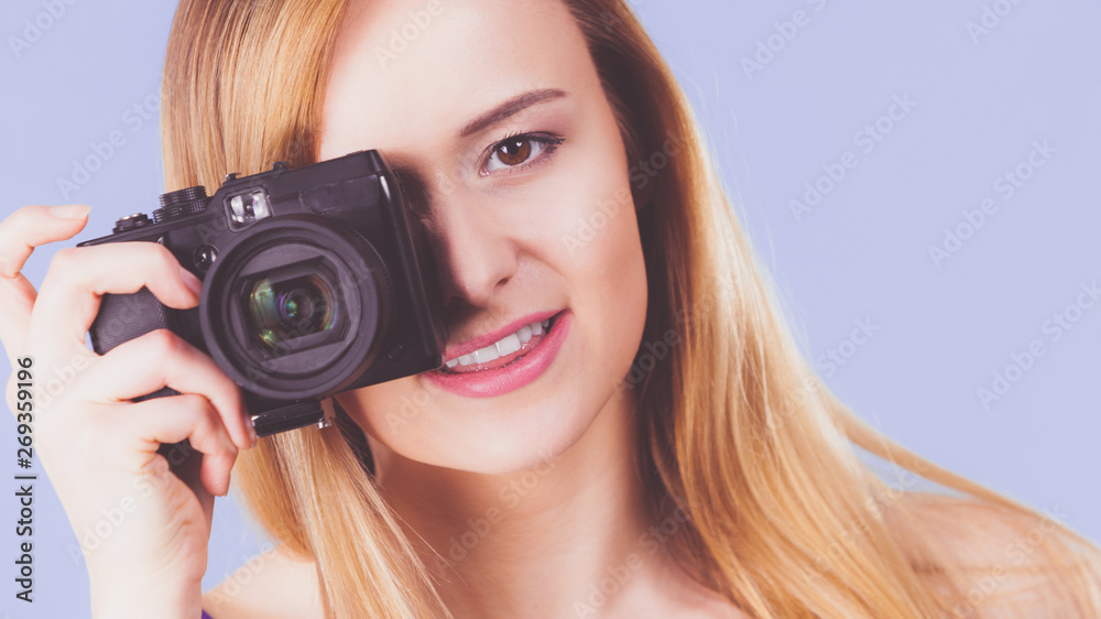 Blonde woman with camera on blue Blonde woman with camera on blue