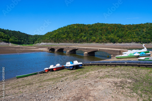 Tretboote am Ufer des Edersees und die Brücke Asel im Hintergrund, nur sichtbar bei Niedrigwasser