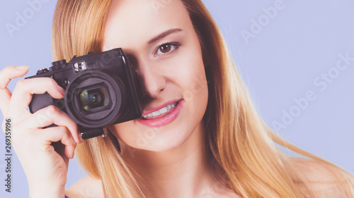 Blonde woman with camera on blue © anetlanda