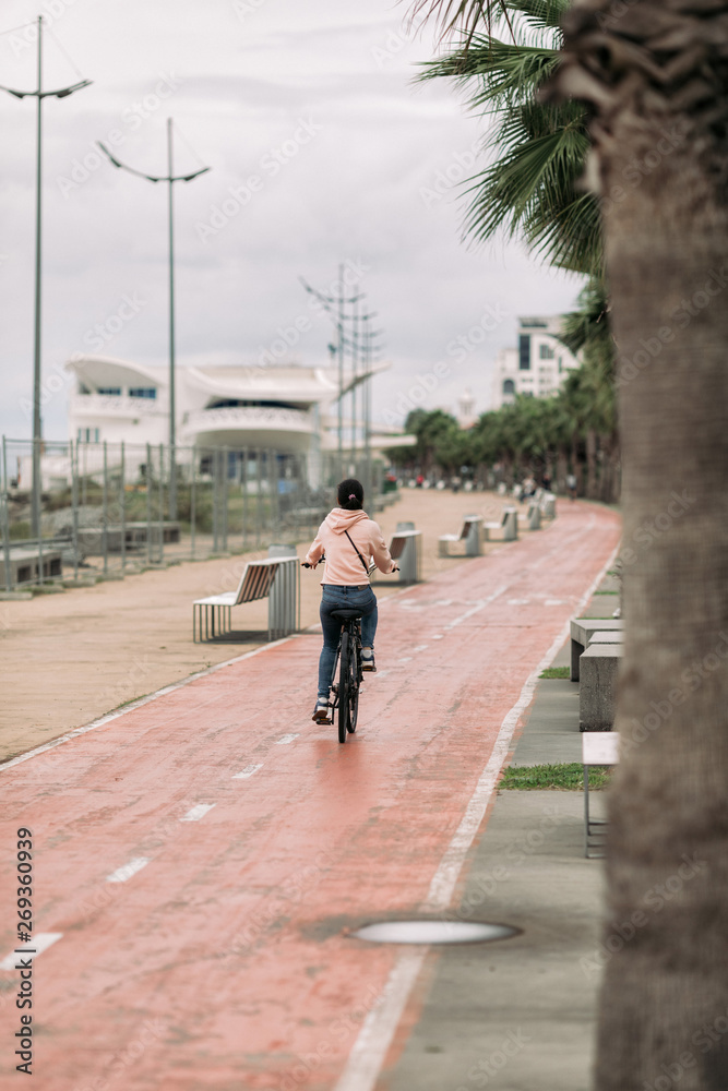 woman cyclist riding a bike on bike path on the embankment