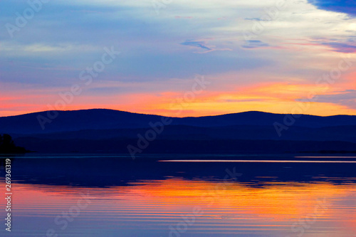 Evening sky over a mountain lake © Julia Studenikina