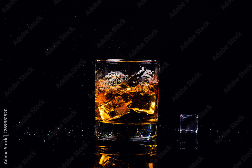 Isolated shot of whiskey with splash on black background
