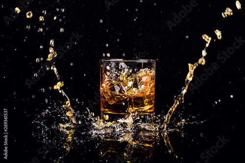 Isolated shot of whiskey with splash on black background