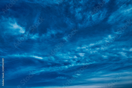 Concept photo of a blue sky background with feather clouds on a sunny day with a dry sun.