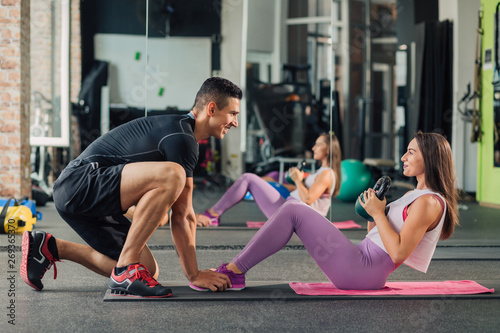 Young woman with personal trainer in the gym