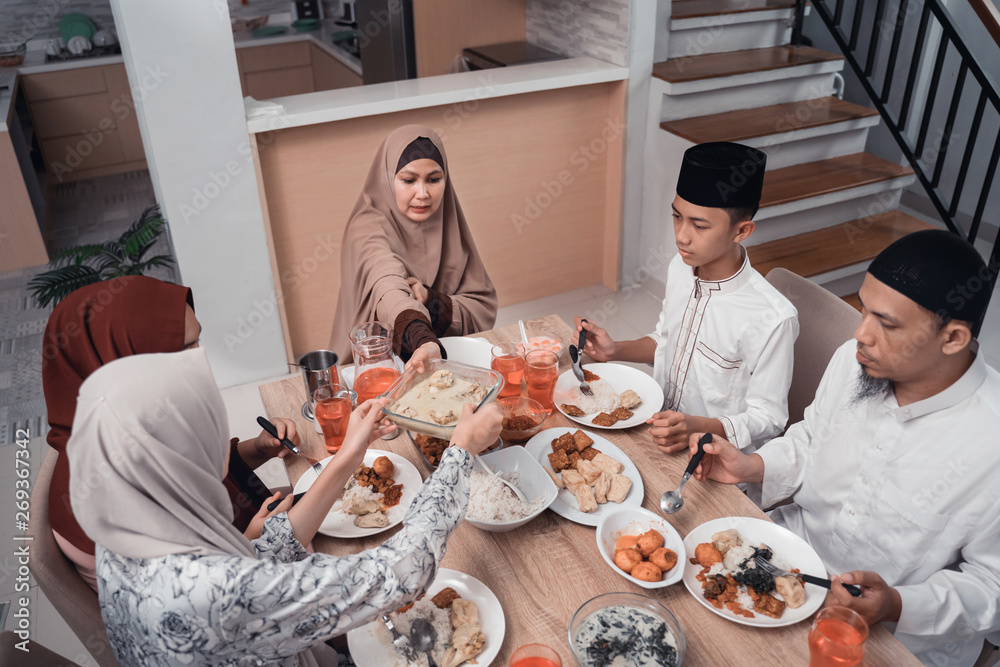 asian muslim family iftar dinner together at home. break fasting concept