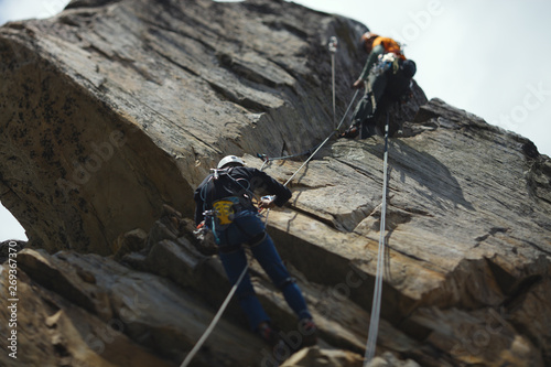 Abstract image of a two person rope of climbers on a rock tower. Tilt-Shift effect.