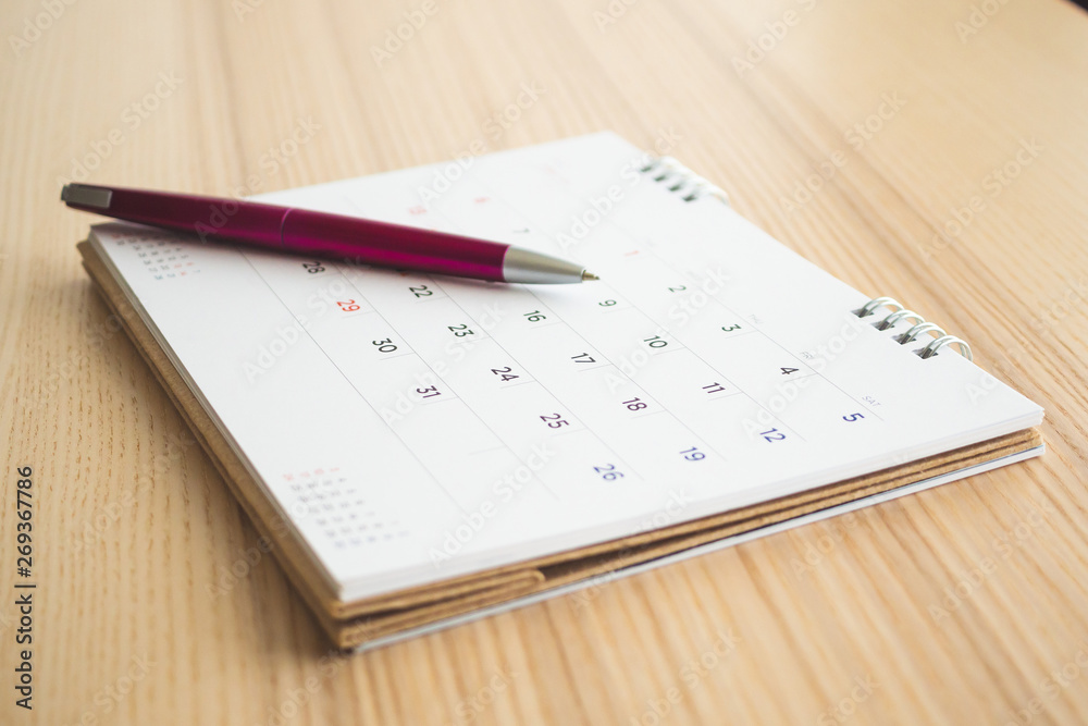 calendar page with pen on wood table background calendar page with pen on wood table background