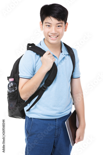 Smiling little student boy in blue polo t-shirt in with books and bag.
