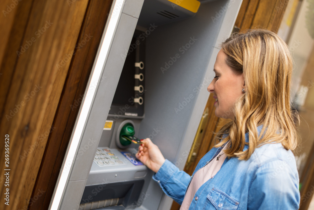 Young woman taking money from ATM Young woman taking money from ATM