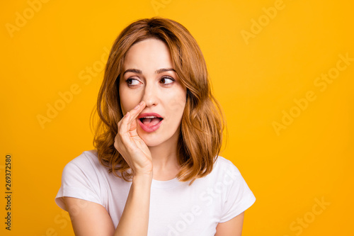 Close up photo beautiful amazing she her foxy lady hold arm hand talking tell speak say secrecy information news novelty not loud chatterbox wear casual white t-shirt isolated yellow background