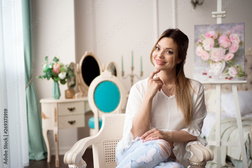 A woman artist with a picture on an easel at home. The painter paints oil paintings. A woman artist with a picture on an easel at home. The painter paints oil paintings.