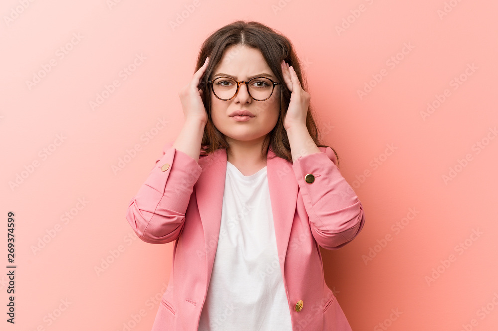 Young plus size business caucasian woman focused on a task, keeping him forefingers pointing head. Young plus size business caucasian woman focused on a task, keeping him forefingers pointing head.