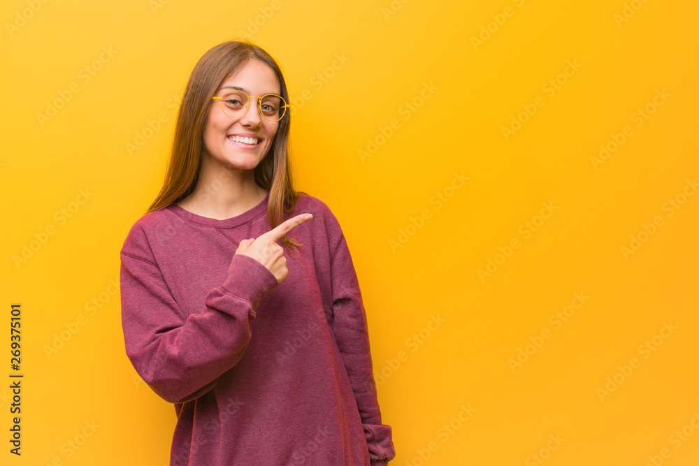 Young casual woman smiling and pointing to the side Young casual woman smiling and pointing to the side