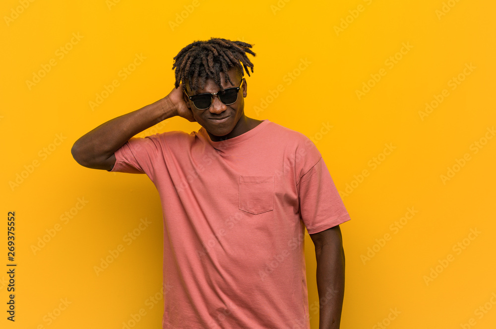 Young casual black man wearing sunglasses suffering neck pain due to sedentary lifestyle. Young casual black man wearing sunglasses suffering neck pain due to sedentary lifestyle.